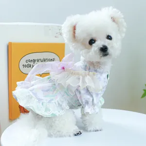 Detail of light purple floral pet dress with lace edges and mesh ribbon bow on a white dog