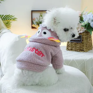 Détail d'un sweat à capuche rose en peluche pour animal avec ailes et broderie monster
