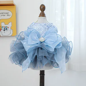 Detail view of light blue pet wedding dress with tiered tulle, lace embroidery and a bow
