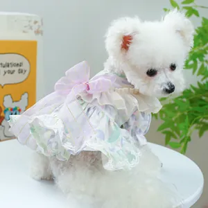 Close-up of floral pet dress with large lavender bow, lace trim and ruffle details