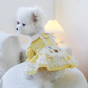 Détail de la robe pour chien avec motif à carreaux jaunes et broderie florale