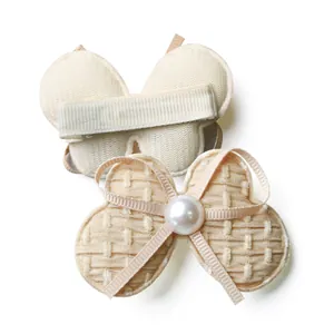 Detail of beige bow hair clip set with wavy fabric and pearl on ribbed metal clips