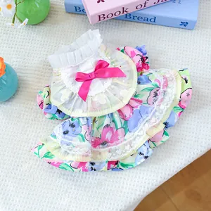 Close-up of floral pet dress with lace trim and elegant pink satin bow detail
