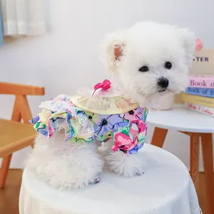 Close-up of floral dog dress featuring lace collar, pink bow, and ruffled hem details