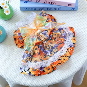 Détail de robe fleurie pour chien avec nœud en organza orange et bordure en dentelle