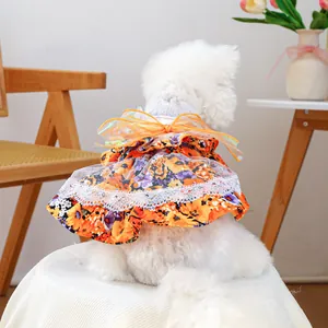 Detail of floral dog dress featuring a large orange bow and white lace trim for small pets