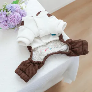 Detail van warme huisdierjas van wit fleece met bruine wafelgebreide mouwen op kantwerk