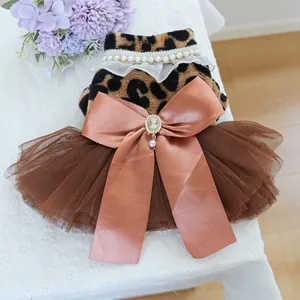 Detail of leopard print pet dress featuring a large satin bow with pearl pendant