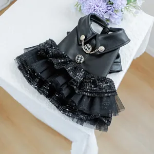 Detail van huisdierjurk met kunstlederen lijfje, houndstooth knopen en rok van lovertjesgaas