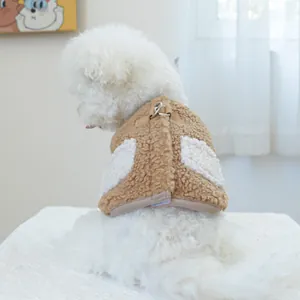 Dettaglio della pettorina marrone in peluche per cani con anello a D su un cane bianco