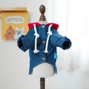 Detail van denim jasje voor huisdieren met rode capuchon en metalen knopen