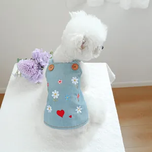 Dettaglio vestito di jeans per cani con margherite e cuori ricamati su tessuto blu chiaro