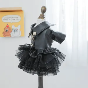 Detail van een hondenkledingstuk met zwarte PU-leren top, gouden knopen en lovertjesrok