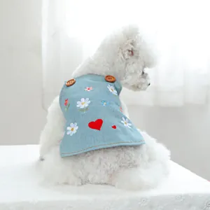 Dettaglio del vestito in denim azzurro per cani con margherite e cuori ricamati