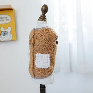 Dettaglio del gilet sherpa marrone per cani con anello a D in metallo e tasca decorativa bianca