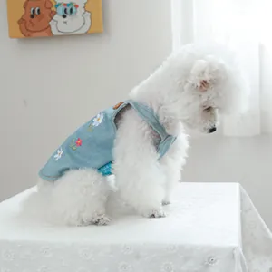 Dettaglio del ricamo di fiori bianchi e rossi sul gilet di jeans blu per cani e gatti