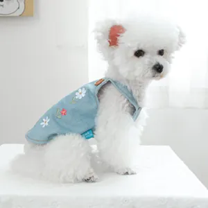 Dettaglio del gilet di jeans per cani azzurro con ricami floreali rossi e bianchi