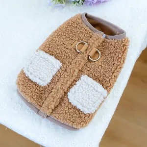 Dettaglio del gilet marrone in sherpa per cani con tasche bianche e anello a D in metallo