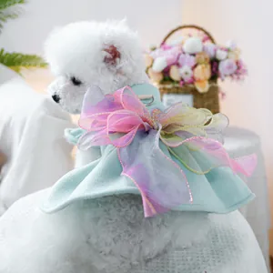 Dettaglio vestito per cani con fiocco arcobaleno e anello a D su tessuto blu chiaro