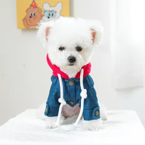 Detail van een denim jasje voor huisdieren met rode capuchon en trekkoorden voor honden