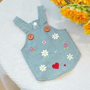 Dettaglio del vestito in denim per animali con ricami di margherite e bottoni in legno