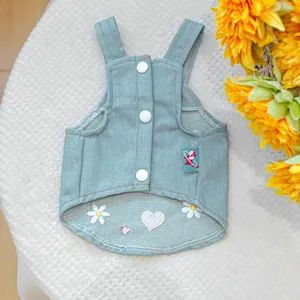 Dettaglio del gilet in denim per animali con bottoni bianchi e ricami di margherite