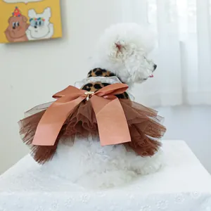Close-up of leopard pet dress with pearl collar and large satin bow on white dog