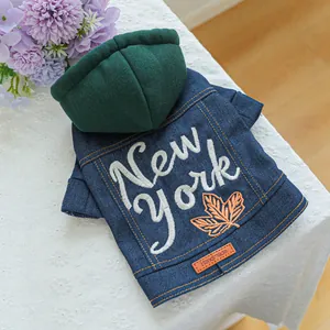Detail van denim hondentrui met New York borduursel op wit kanten tafelkleed