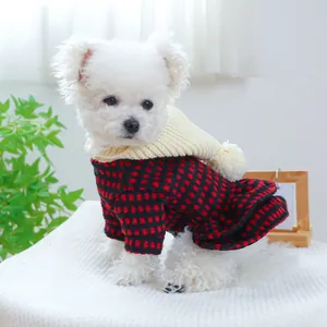 Dettaglio vestito per cani a quadri rossi e neri con cappuccio in maglia bianco con pompon