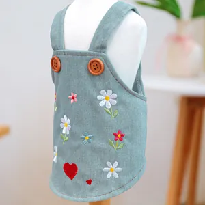 Dettaglio salopette in denim per animali con ricami floreali e bottoni in legno