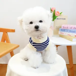 Detail of blue and white striped dog vest with ribbed edges worn by a white Bichon dog