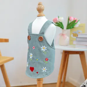 Dettaglio del vestito in denim azzurro per animali con ricami floreali e bottoni