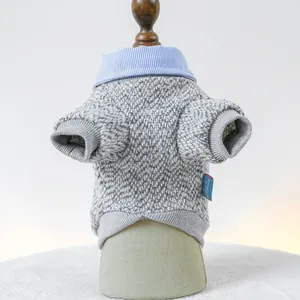 Detail of grey knitted pet sweater with blue striped shirt collar and brand woven label