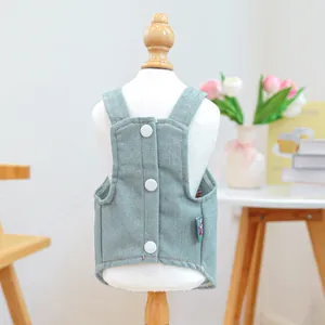 Dettaglio gilet in denim azzurro per animali domestici con tre bottoni bianchi su manichino