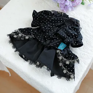 Détail d'une robe pour animaux en velours noir à pois blancs avec dentelle et ourlet doublé