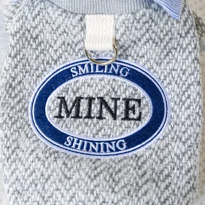 Detail of dog vest with MINE embroidery, knitted fabric texture and metal D-ring for leash