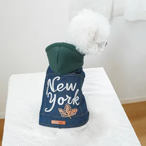 Detailopname van denim hondenvest met New York borduursel en oranje esdoornblad decoratie