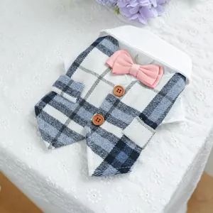 Detailed view of pet tuxedo vest with blue plaid pattern and pink bowtie on lace