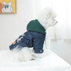 Detail van spijkerjasje voor honden met groene capuchon, knopen en wit borduursel