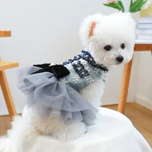 Dettaglio vestito per animali con ricami floreali blu, perline scure e fiocco di velluto
