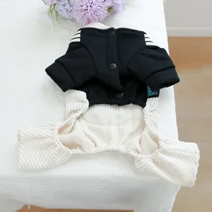 Detailed view of dog jumpsuit with striped shoulders and snap buttons on a floral setting