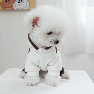 Vooraanzicht detail van een witte fleece hondenhoodie met drukknopen en bruine biezen