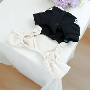 Detail of pet jumpsuit featuring black snap buttons and soft cream ribbed fabric texture