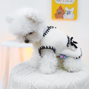 Nahaufnahme der cremefarbenen Fleece-Hundeweste mit schwarzen Samtschleifen und Strass