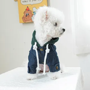 Detail van spijkerjasje voor honden met groene capuchon en witte koorden op de hond