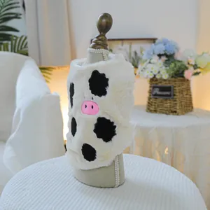 Dettaglio del gilet in peluche crema per animali con stampa mucca e ricamo rosa