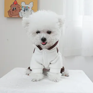 Detailopname van zachte fleece hondensuite met capuchon en bruine biezen op hond