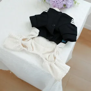 Close-up of black pet jumpsuit with ribbed cuffs and snap buttons on lace background
