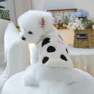 Dettaglio del morbido gilet per cani con stampa a mucca e dettagli rosa su un Bichon