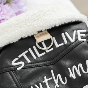 Detail of pet leather jacket featuring black faux leather and white embroidery